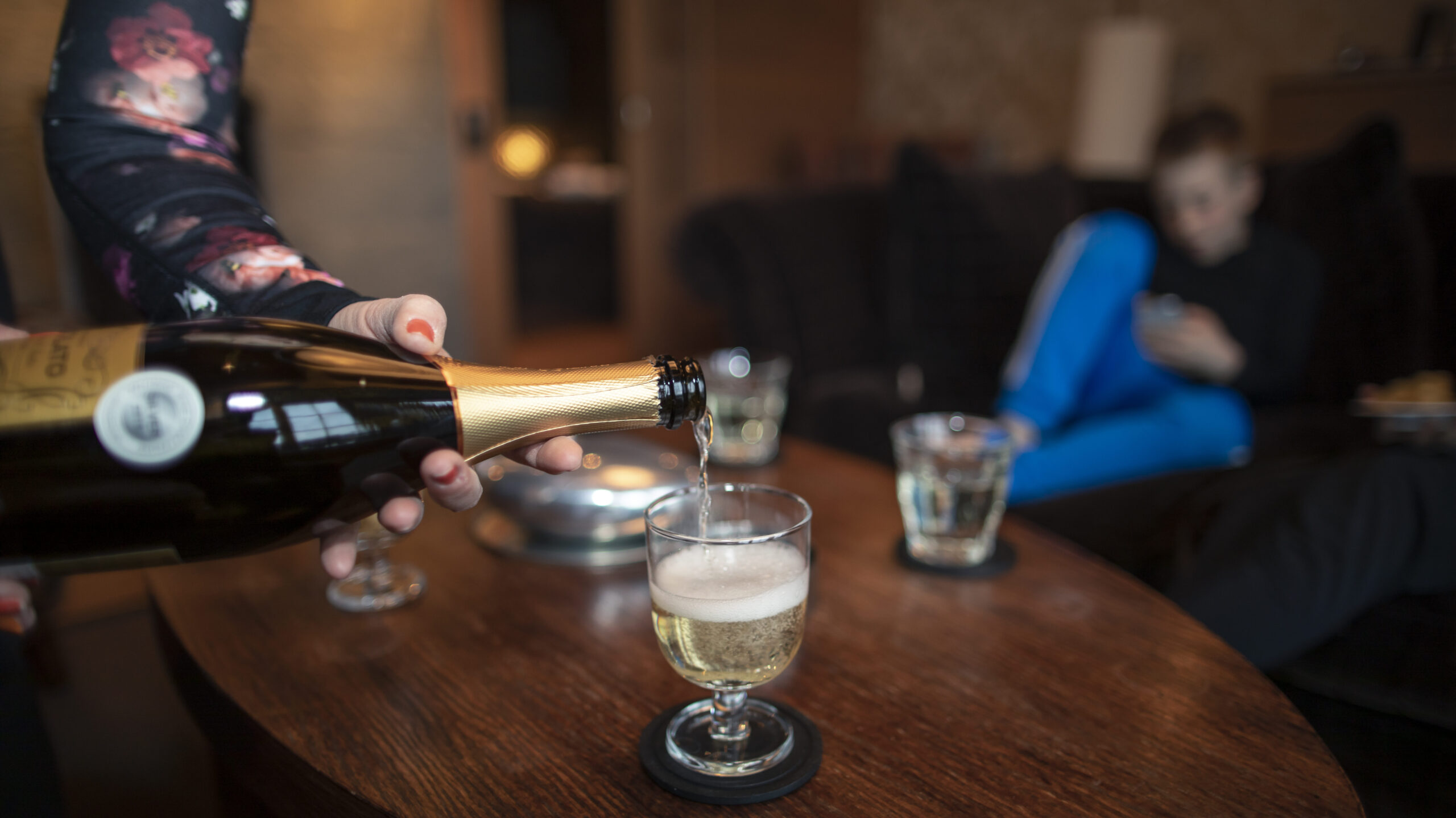 Salongen i vår Svit Lodge, soffbord där det hälls upp mousserande dryck i glas