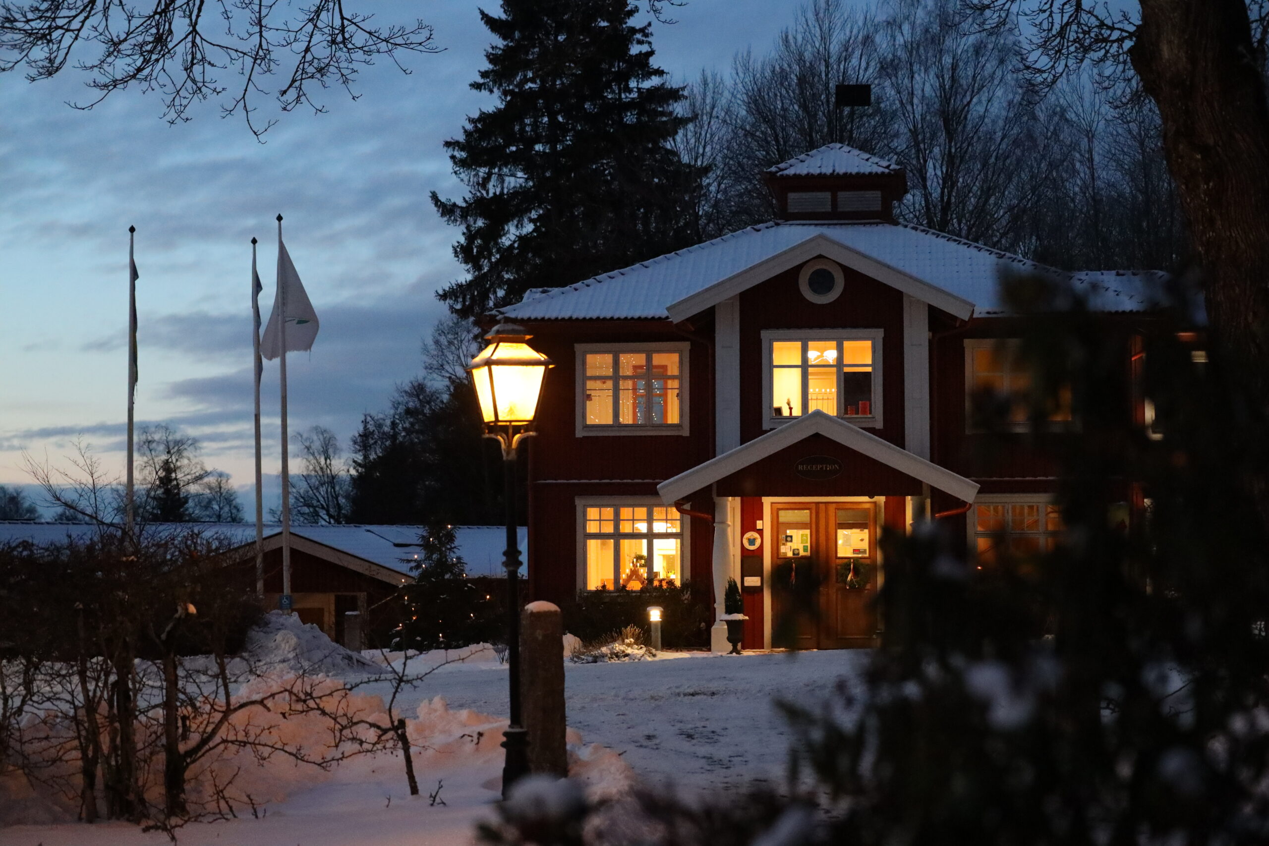 Exteriörbild på Receptionsvillan på Hestraviken hotell och spa vid Isaberg i Småland, i julstämning med vinterlandskap och juldekorationer.